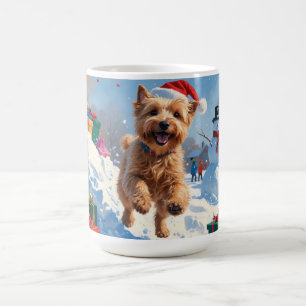 Wheaten Terrier läuft im Schnee mit Weihnachtsmütz Kaffeetasse