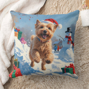 Wheaten Terrier läuft im Schnee mit Weihnachtsmütz Kissen