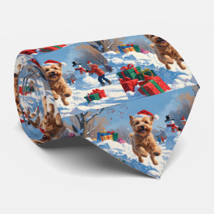 Wheaten Terrier läuft im Schnee mit Weihnachtsmütz Krawatte