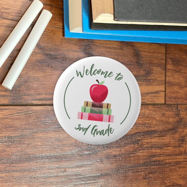 Willkommen beim Rund-Button "Apfelbücher der dritt Button (Welcome to 3rd grade white round back-to-school button with a red apple and books .)