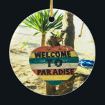 Willkommen im Paradies Beach Ocean Keramik Ornament<br><div class="desc">Willkommen im Paradies Beach Ocean Schöner,  weicher Sandstrand mit einer grünen Palme im Hintergrund. Dieses Schild ist rot,  gelb,  blau und weiß gestrichen und heißt WELCOME TO PARADISE.</div>