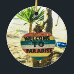 Willkommen im Paradies Beach Ocean Keramik Ornament<br><div class="desc">Willkommen im Paradies Beach Ocean Schöner,  weicher Sandstrand mit einer grünen Palme im Hintergrund. Dieses Schild ist rot,  gelb,  blau und weiß gestrichen und heißt WELCOME TO PARADISE.</div>
