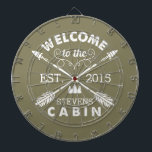 Willkommen in der Hütte | Rustikale Pfeile Persona Dartscheibe<br><div class="desc">Verbringen Sie erholsame Stunden mit diesem lustigen,  einzigartigen Dartboard. Das Design hat einen olivgrünen Hintergrund mit "Welcome to the [Name] Cabin" in rustikalem Blocktext und zwei gekreuzten Pfeilen. Passen Sie Ihren Familiennamen und das Jahr an,  in dem Sie sich befinden. Macht ein phantastisches Hauswärmespiele oder Geschenk für Ihre Wochenendwirte!</div>