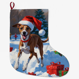 Windhund läuft im Schnee mit Weihnachtsmütze Großer Weihnachtsstrumpf
