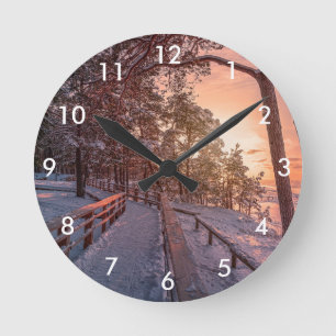 Winter Sonnenuntergang im Kiefernwald in der Nähe  Runde Wanduhr