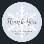 Winter Wedding Dusty Blue Snowflake Danke Runder Aufkleber<br><div class="desc">Dieses Hochzeitsdesign im Winter besticht durch eine schlichte,  weiße Schneeflocke auf einem staubblauen Hintergrund,  wobei die Worte "Danke" in einem eleganten grauen Schriftart überlagert sind. Personalisieren Sie mit den Namen der Braut und des Bräutigams und dem Hochzeitstag in grauem Sans Serif Schriftart.</div>