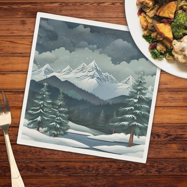 Winterwaldgebirgslandschaft Serviette (A mountain scene on a napkin that is on a wooden table with a plate of food and a fork)