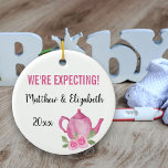 Wir erwarten, dass ein Baby Teekanne züchtet Keramik Ornament<br><div class="desc">Hübsche Ornamente für Ihre Schwangerschaft, die Sie personalisieren können. Eine Seite hat rosa Blume und handgeschriebene Schriftzypografie, die lautet: "Ein kleines Mädchen braut". Auf der anderen Seite befindet sich ein niedlich rosa Teekessel und Ihr eigener Text. Die Vorlage ist für Sie Set, um die Beispielworte zu bearbeiten, die "Wir erwarten...</div>
