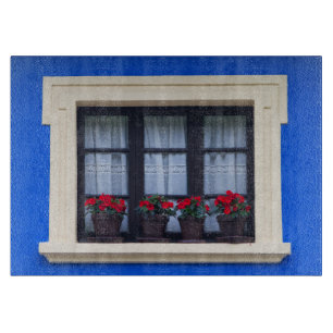 Wohnhaus mit Blumen in den Fenstern Schneidebrett