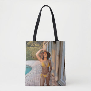Woman in yellow bikini standing on brown brick flo