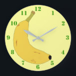YELLOW BANANA IN POP ART STYLE WITH GREEN NUMBERS GROßE WANDUHR<br><div class="desc">A light yellow Clock with green numbers,  and a digital illustration of a tropical banana. Available in other options. Visit our store for more Wall Clocks and other Home Gifts.</div>