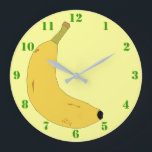 YELLOW BANANA IN POP ART STYLE WITH GREEN NUMBERS GROßE WANDUHR<br><div class="desc">A light yellow Clock with green numbers,  and a digital illustration of a tropical banana. Available in other options. Visit our store for more Wall Clocks and other Home Gifts.</div>