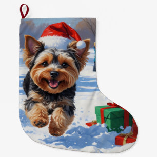 Yorkipoo läuft im Schnee mit Weihnachtsmütze Großer Weihnachtsstrumpf