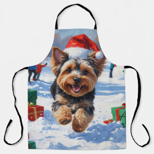 Yorkipoo läuft im Schnee mit Weihnachtsmütze Schürze