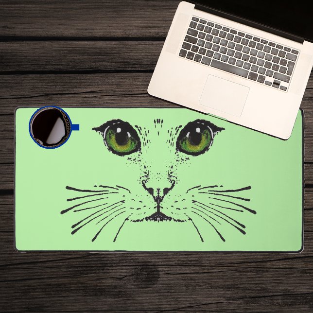 Zeichnend Black Cat Face Intensive Green Eyes Whis Schreibtischunterlage (Black illustration of the face of a cat with green eyes long whiskers on light green desk mat.)