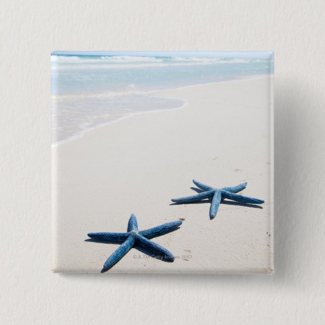 Zwei blaue Seesterne am Rande des Wassers auf trop Button (Vorderseite)