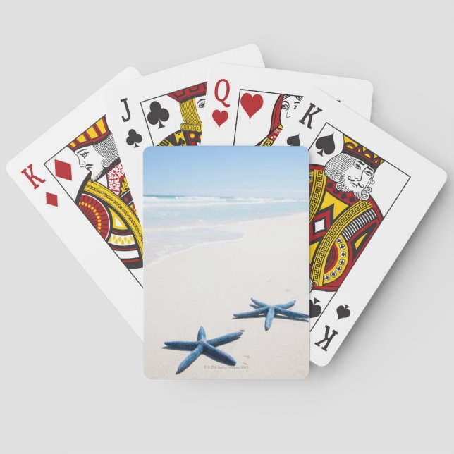 Zwei blaue Seesterne am Rande des Wassers auf trop Spielkarten (Rückseite)