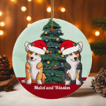Zwei Corgi Tricolor Red White Weihnachtsmannmütze  Keramik Ornament<br><div class="desc">Dieses wunderschöne Pembroke Welsh Corgi Hundeschmuck hat zwei Hunde mit einem Weihnachtsmädchen mit einer bezaubernden Kopfneigung. Ein Dreifarbenjunge und ein rot-weißes Hündchen sitzen vor einem hübschen Weihnachtsbaum,  der mit bunten Ornamenten geschmückt ist. Personalisieren Sie die Namen Ihres Haustieres in einem hübschen Kursiv unter dem wunderbaren zeichn meiner Lieblingsrasse.</div>