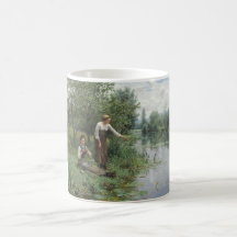 Zwei Frauen fischen auf dem Gras am Fluss