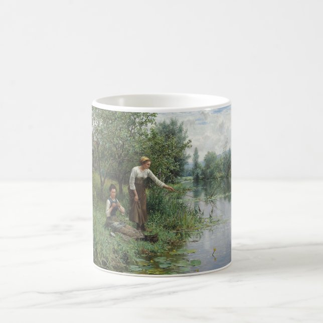Zwei Frauen fischen auf dem Gras am Fluss Kaffeetasse (Mittel)