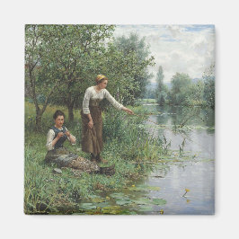 Zwei Frauen fischen auf dem Gras am Fluss Magnet