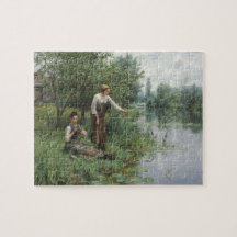 Zwei Frauen fischen auf dem Gras am Fluss