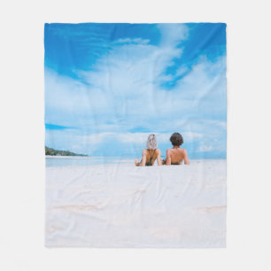 Zwei Frauen liegen auf weißem Sand und liegen dire Fleecedecke