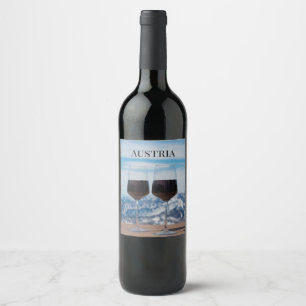 Zwei Gläser Rotwein gegen Berge Weinetikett