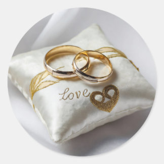 Zwei Hochzeitsringe auf einem weißen Kissen Runder Aufkleber