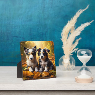 Zwei Niedliche Welpen spielen in Herbstlauben Fotoplatte