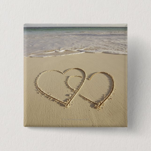 Zwei Oberherzen, die am Strand gezeichnet werden Button (Vorderseite)