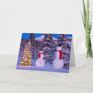 Zwei Snowmen tauschen Geschenke vom Baum Feiertagskarte