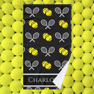 Zwei Tennisbälle und ein schwarzes Racketmuster Handtuch