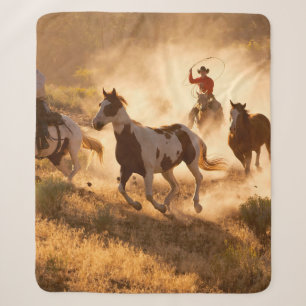 Zwei westliche Cowboys reiten Pferde und werfen wi Sherpadecke