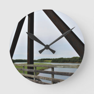 Zwischen den Stangen des Rosts Runde Wanduhr